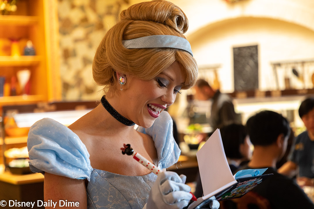 Picture of Cinderella signing an autograph book.